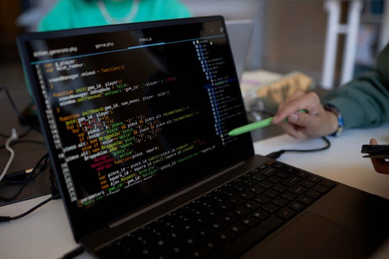 focus-on-laptop-screen-with-coded-data-and-pen-hel-2025-02-11-15-42-45-utc